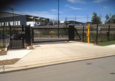black, sliding, automated gate with yellow intercom and entry system