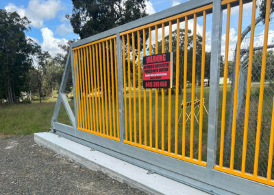 sliding gate, automated, at commercial property, with yellow bars